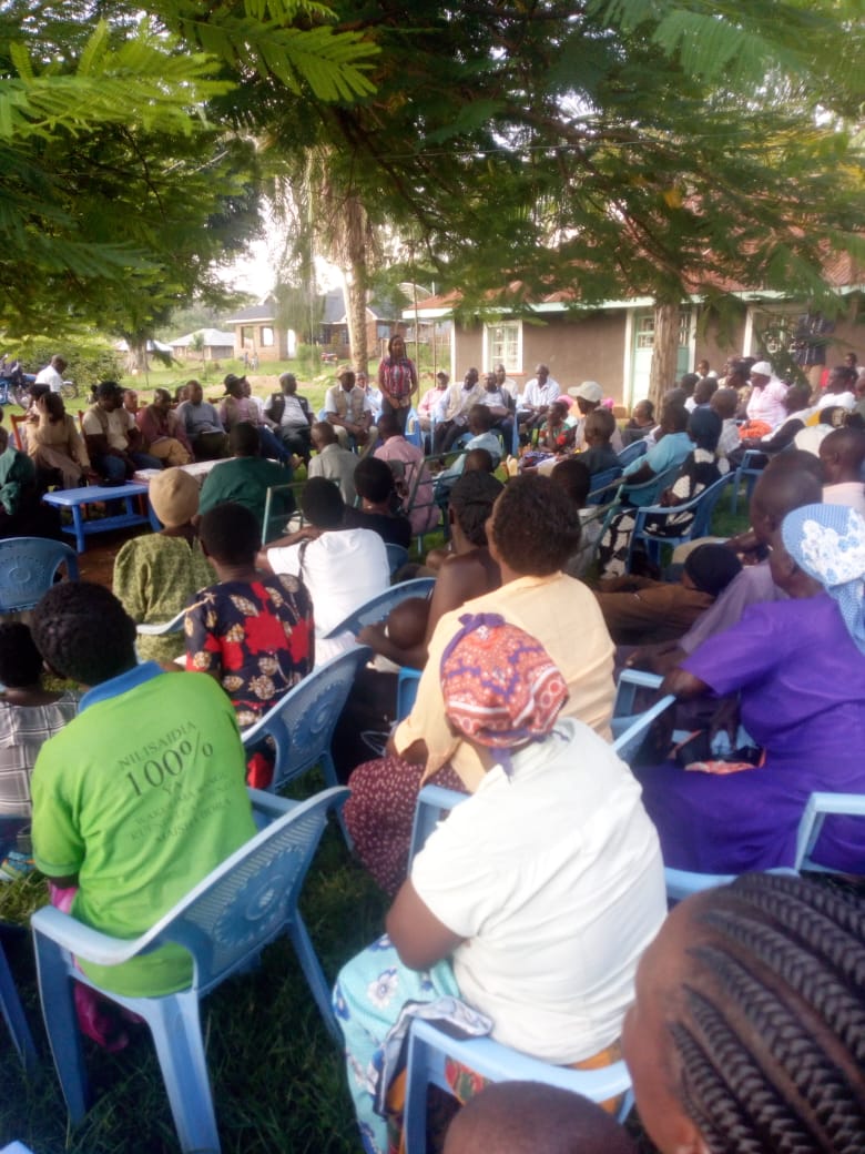 Community members gathered for an NGERO meeting under a tree